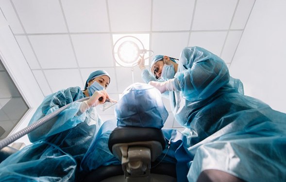 an oral surgeon performing dental implant placement surgery