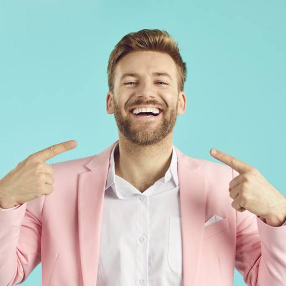 Happy man pointing at his healthy teeth