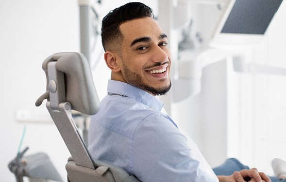 Man smiling while sitting in dental chair