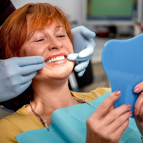 A senior woman admiring her new dental implants