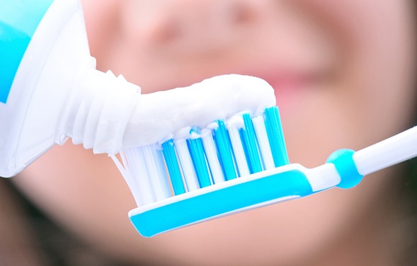 A closeup of a toothbrush having toothpaste applied to it