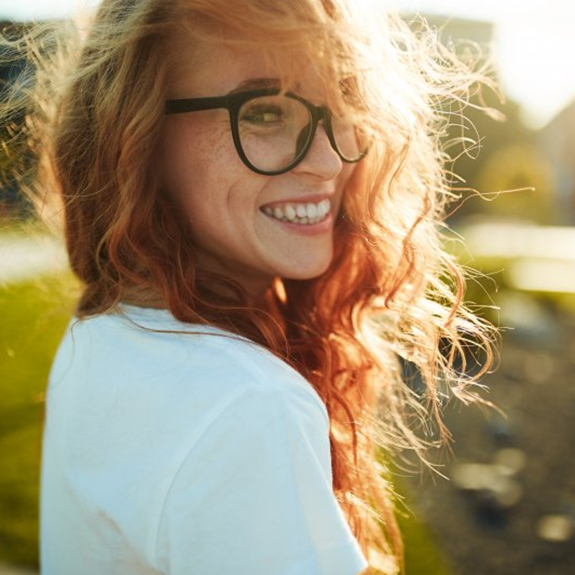 a woman smiling after getting dental implants in Tulsa