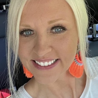 Smiling female dental patient in Tulsa sitting in car