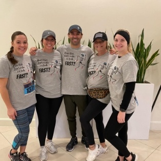 Five smiling dental team members in Tulsa wearing matching shirts