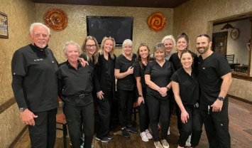 Tulsa dentist and dental team smiling in dental office waiting room