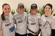 Four smiling dental team members in Tulsa wearing matching T shirts