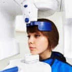 Woman receiving 3 D cone beam digital dental x ray scans
