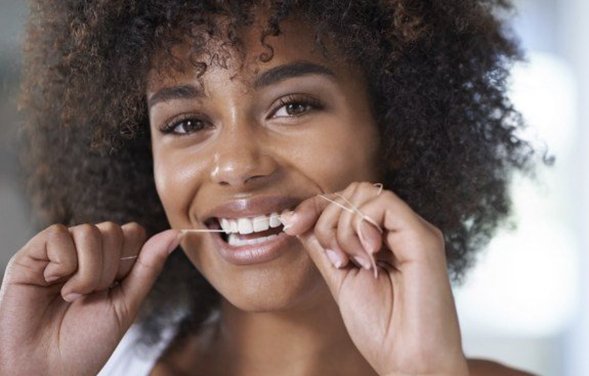 Woman smiling while eating salad and drinking orange juice