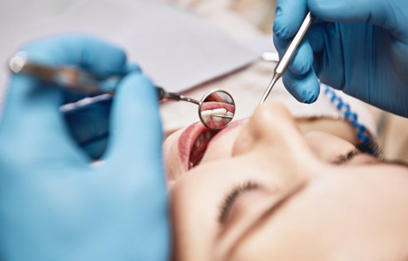 Dentist inspecting a patient’s teeth