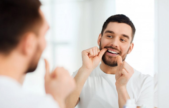Patient flossing his teeth
