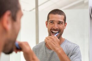Man brushing his teeth with fluoride toothpaste